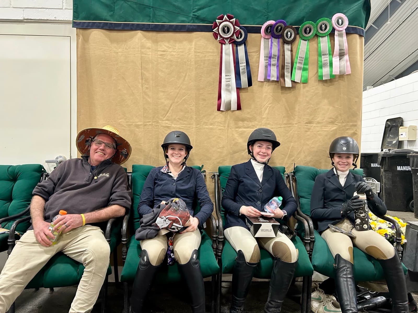Tully with her trainer and teammates holding ribbons after a show.