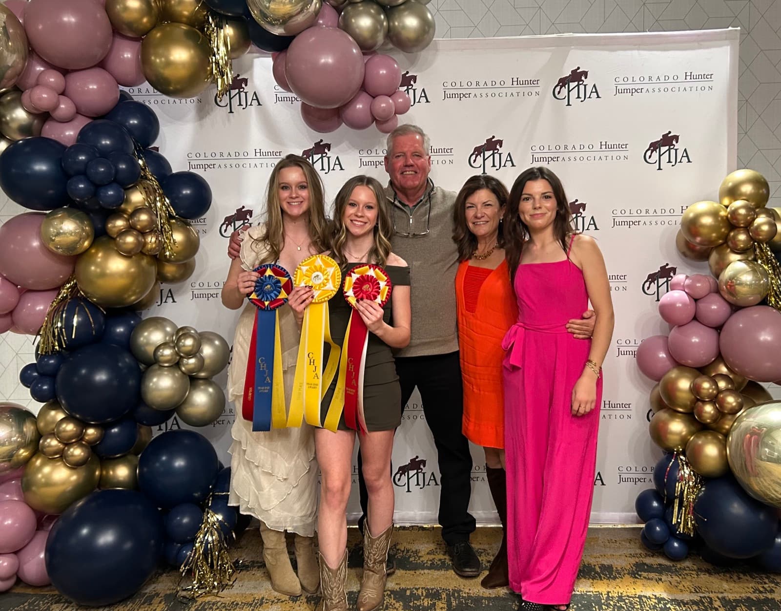 Tully with her trainer and family holding ribbons at the CHJA year-end awards.